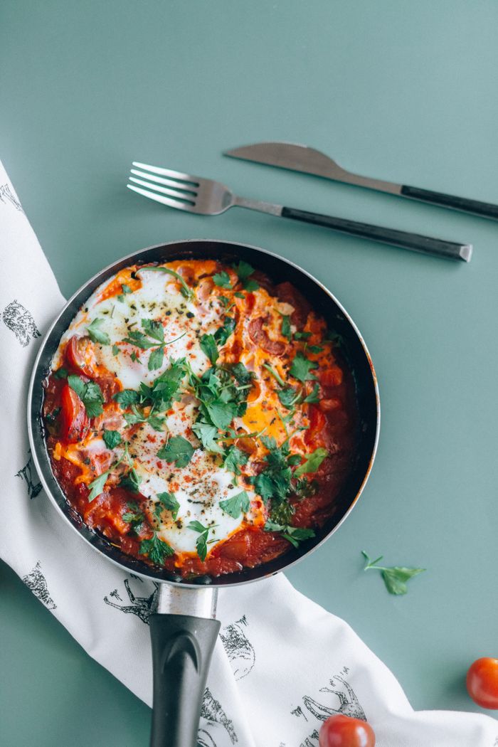 Delicious shakshuka in a pan garnished with fresh parsley, perfect for a healthy meal.