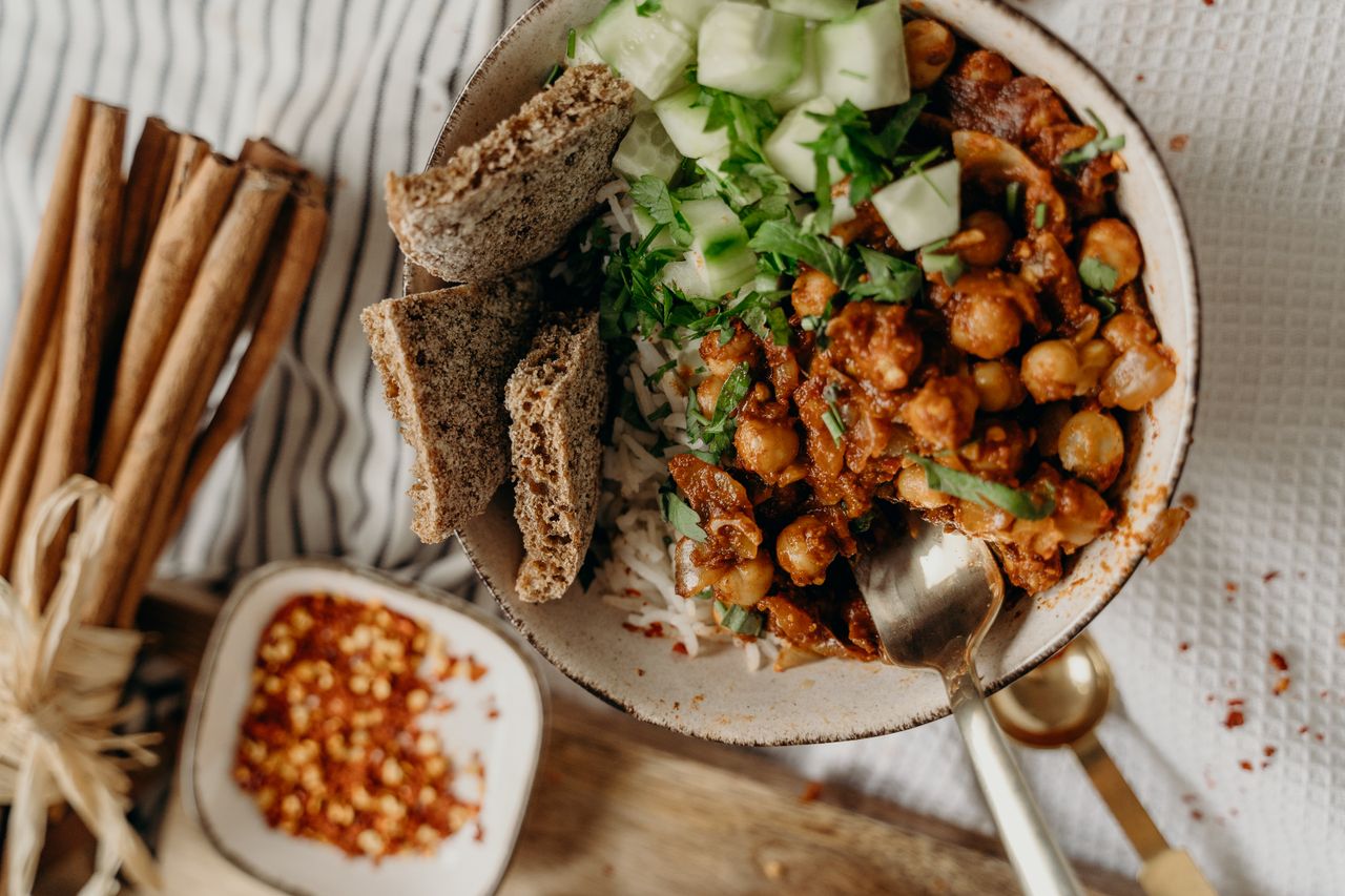 services-01 Delicious vegan bowl of chickpeas, rice, and cucumber, garnished with fresh herbs and spices.